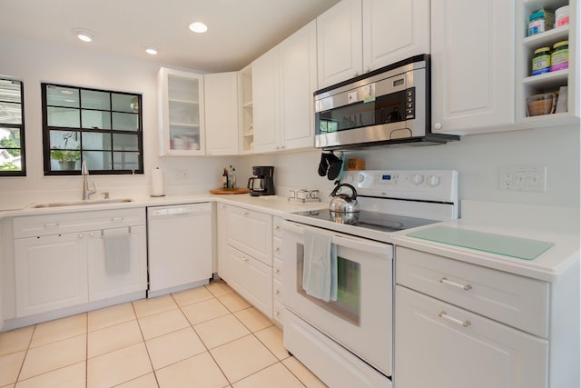 kitchen with white cabinetry, white appliances, sink, and light tile patterned floors