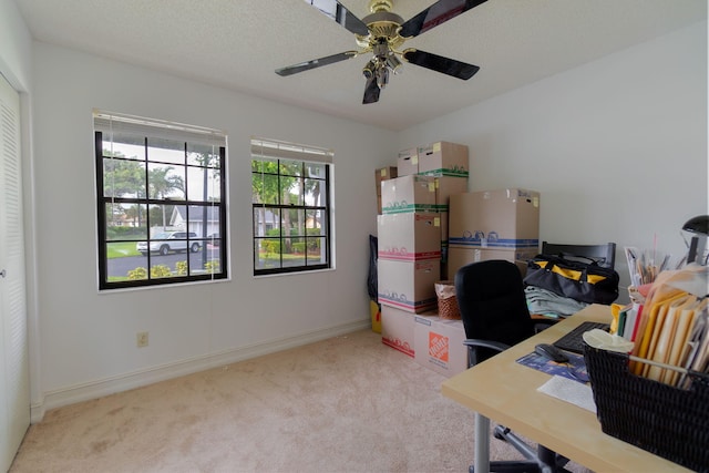 unfurnished office with a textured ceiling, light carpet, and ceiling fan