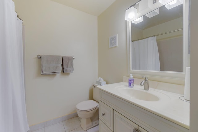 bathroom with toilet, vanity, and tile patterned floors