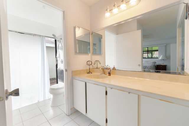 bathroom with toilet, vanity, and tile patterned floors