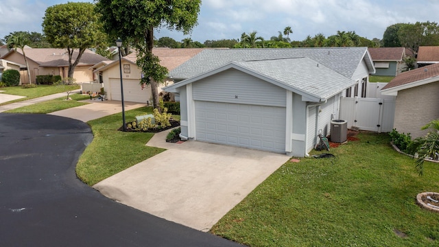 ranch-style house featuring central AC unit, a front yard, and an outbuilding