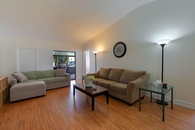 living room with light hardwood / wood-style flooring and vaulted ceiling