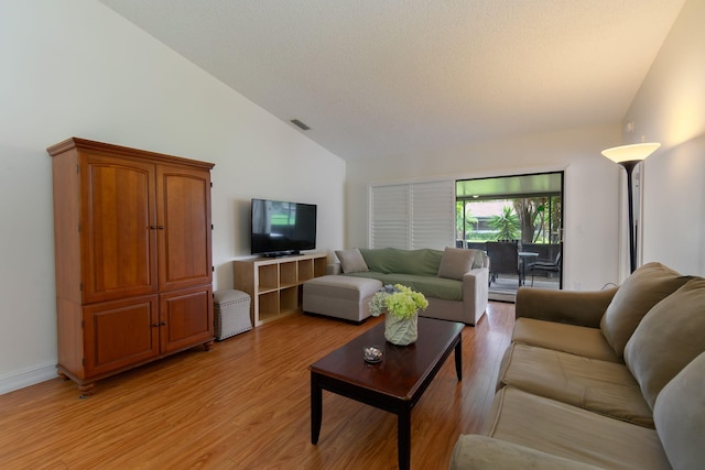 living room featuring high vaulted ceiling and light hardwood / wood-style floors