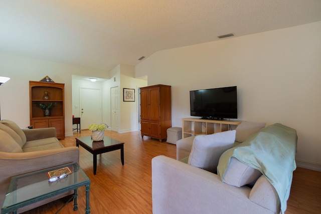 living room with light wood-type flooring and vaulted ceiling