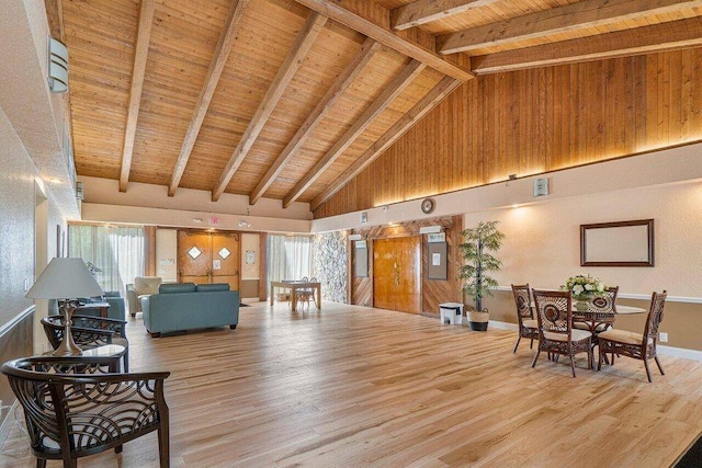 living room featuring wood-type flooring, high vaulted ceiling, a wealth of natural light, and beam ceiling