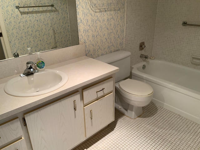 full bathroom with tiled shower / bath combo, tile patterned floors, vanity, and toilet