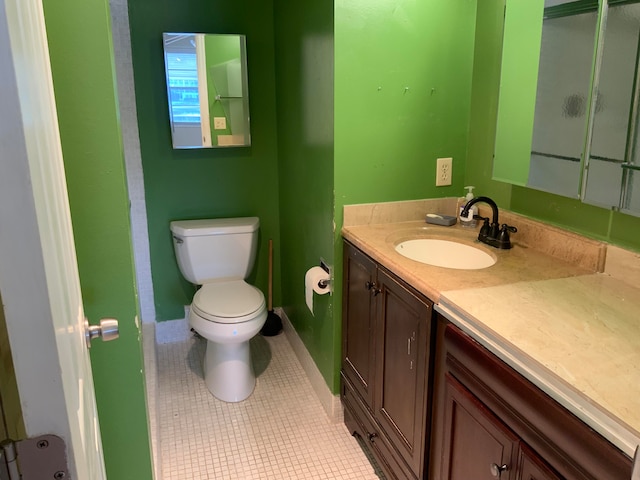 bathroom featuring tile patterned floors, vanity, and toilet