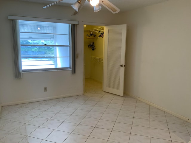 tiled spare room featuring ceiling fan