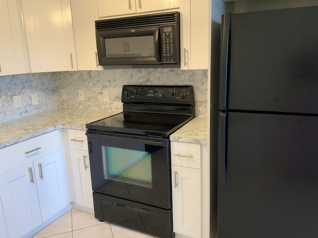 kitchen with light tile patterned flooring, black appliances, white cabinetry, and light stone counters