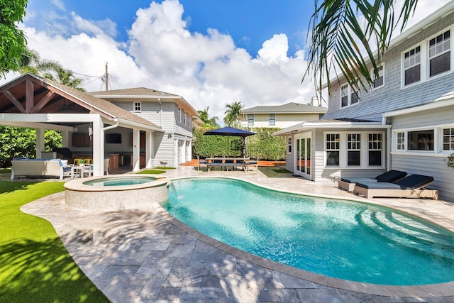 view of swimming pool featuring an in ground hot tub, pool water feature, a patio area, and exterior bar