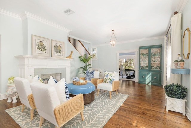 sitting room featuring crown molding, a notable chandelier, and dark wood-type flooring