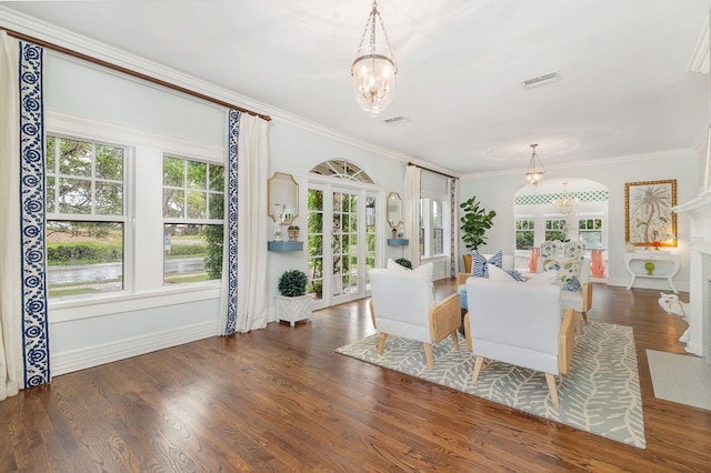 living room with ornamental molding, an inviting chandelier, and dark hardwood / wood-style floors