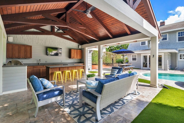 view of patio / terrace featuring an outdoor bar, area for grilling, a gazebo, ceiling fan, and an outdoor living space