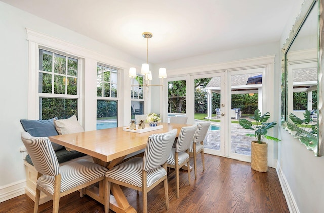 dining area with french doors, dark hardwood / wood-style floors, an inviting chandelier, and plenty of natural light