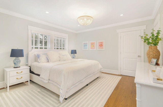 bedroom with a notable chandelier, light hardwood / wood-style floors, and crown molding