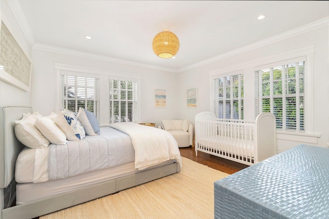 bedroom with multiple windows, ornamental molding, and wood-type flooring