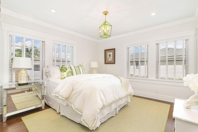 bedroom featuring an inviting chandelier, multiple windows, ornamental molding, and dark wood-type flooring