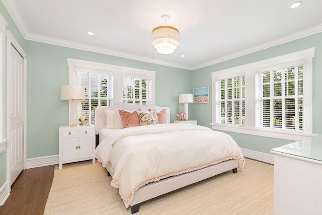 bedroom featuring ornamental molding, multiple windows, and light wood-type flooring