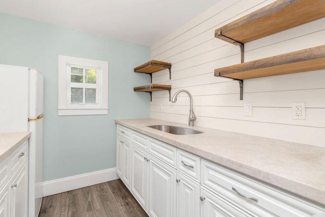 kitchen featuring white cabinets, white fridge, sink, and dark wood-type flooring