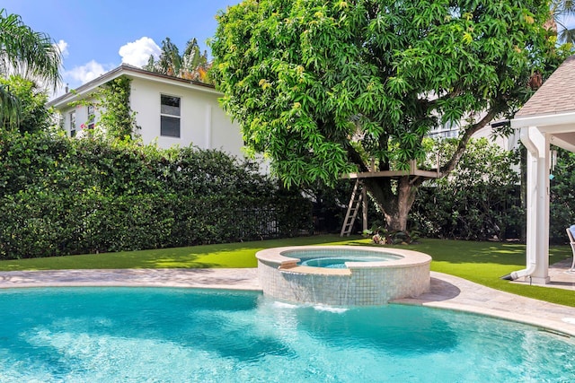 view of pool featuring an in ground hot tub, pool water feature, and a lawn