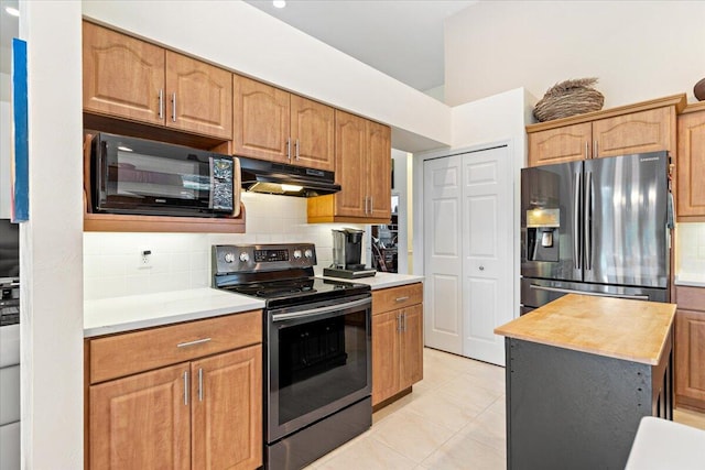 kitchen featuring wooden counters, light tile patterned flooring, stainless steel appliances, and tasteful backsplash