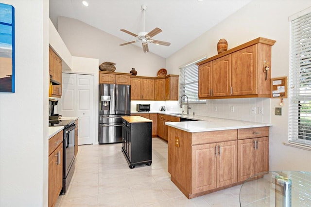 kitchen featuring a kitchen island, sink, stainless steel fridge with ice dispenser, light tile patterned floors, and black range with electric stovetop