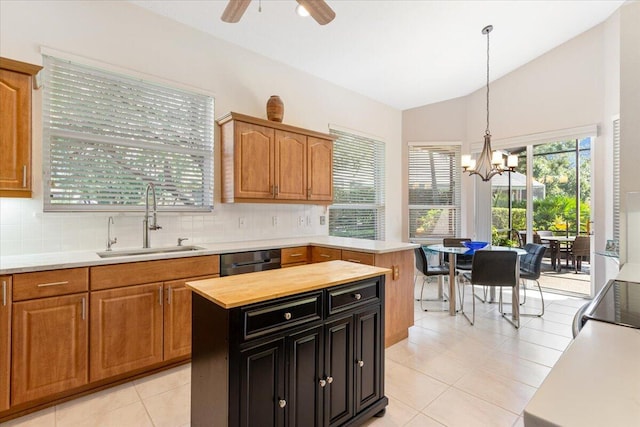 kitchen with lofted ceiling, light tile patterned floors, a kitchen island, pendant lighting, and sink