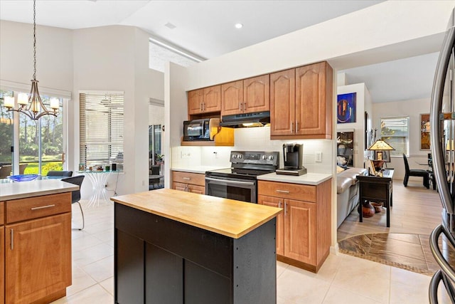 kitchen featuring a kitchen island, stainless steel appliances, backsplash, a notable chandelier, and pendant lighting