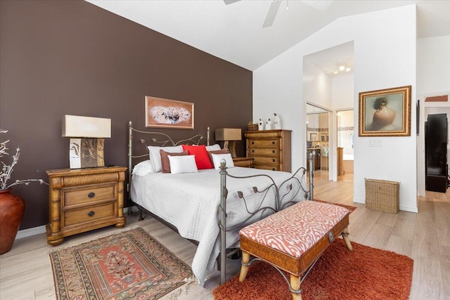 bedroom featuring ensuite bathroom, a closet, light hardwood / wood-style floors, ceiling fan, and lofted ceiling