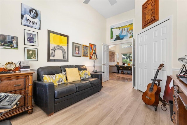 living room featuring light hardwood / wood-style floors, ceiling fan, and vaulted ceiling