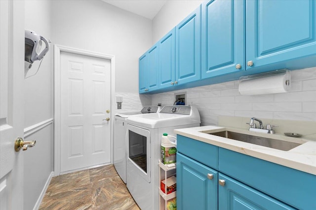 washroom with cabinets, sink, and washing machine and clothes dryer