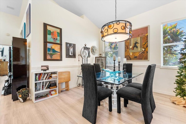 dining area with light hardwood / wood-style floors and lofted ceiling