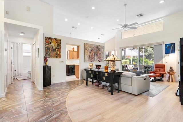 living room featuring light wood-type flooring, high vaulted ceiling, and ceiling fan