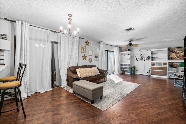 living room with dark wood-type flooring, a textured ceiling, and ceiling fan with notable chandelier