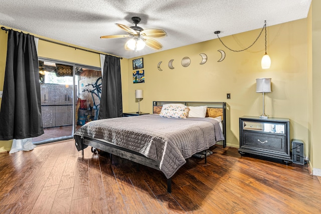 bedroom with wood-type flooring, a textured ceiling, and access to outside