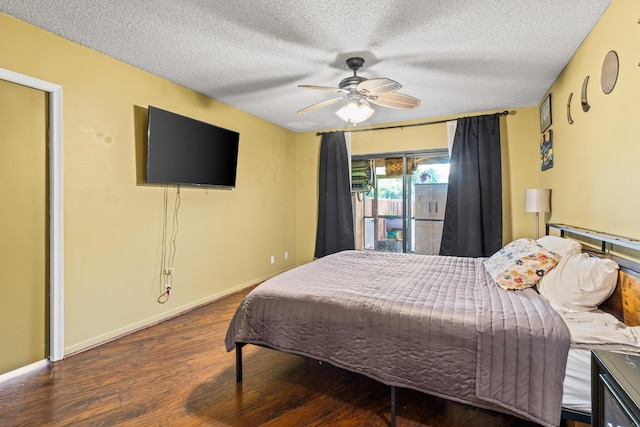 bedroom featuring dark wood-type flooring, ceiling fan, and a textured ceiling