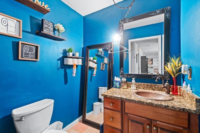 bathroom featuring toilet, vanity, and tile patterned floors