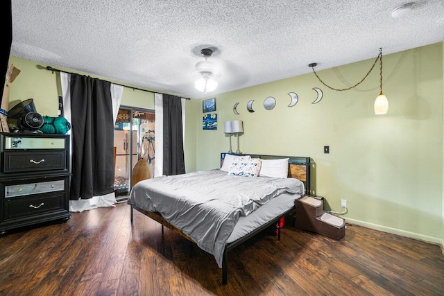 bedroom with dark hardwood / wood-style floors, a textured ceiling, and ceiling fan