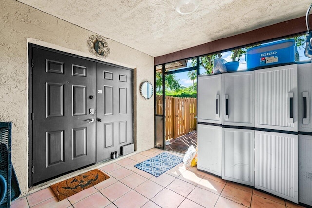 foyer featuring tile patterned flooring and a textured ceiling