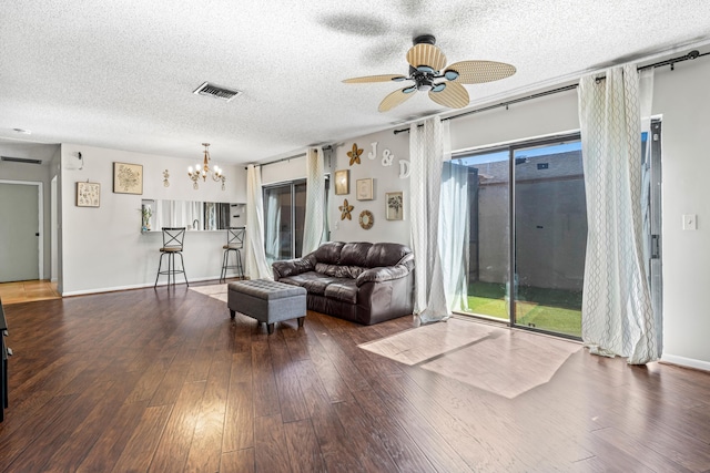 living room featuring wood-type flooring, ceiling fan with notable chandelier, and a textured ceiling