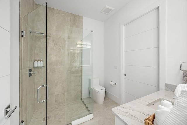 bathroom featuring vanity, a shower with shower door, toilet, and tile patterned flooring