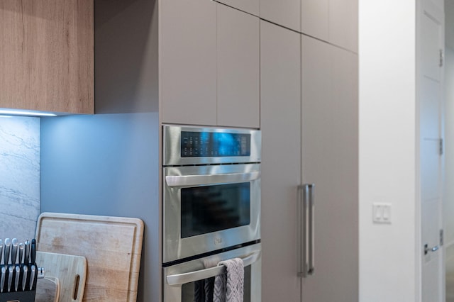 kitchen with double oven and white cabinetry