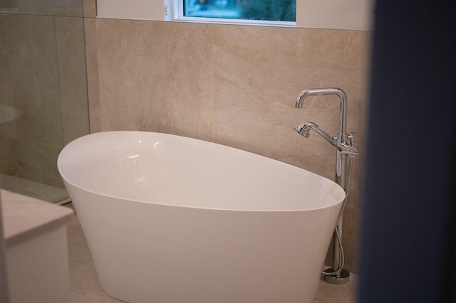 bathroom featuring a tub to relax in and tile patterned floors