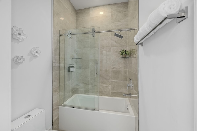 bathroom featuring enclosed tub / shower combo and toilet