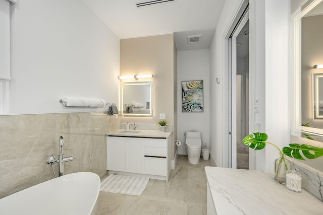 bathroom with toilet, a washtub, and vanity