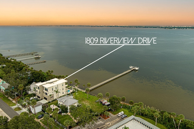 aerial view at dusk featuring a water view