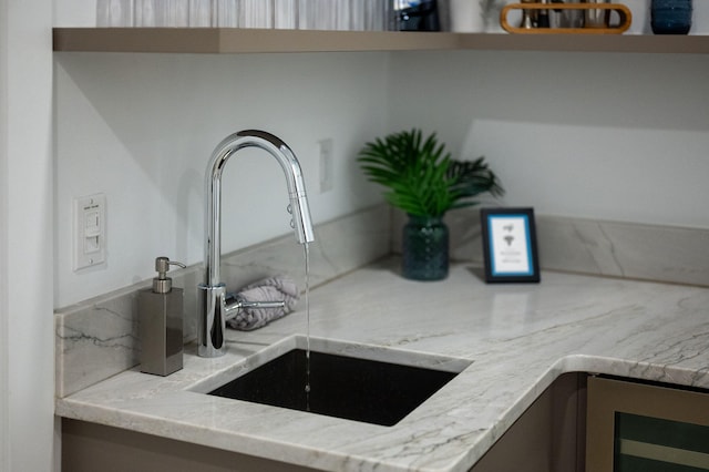 details with light stone countertops, backsplash, and sink