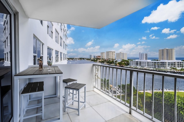 balcony featuring a water view and a city view