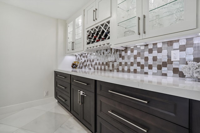 bar with baseboards, a dry bar, and backsplash