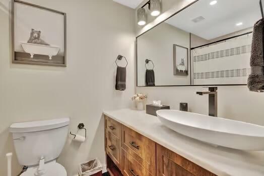 bathroom with vanity, curtained shower, and toilet